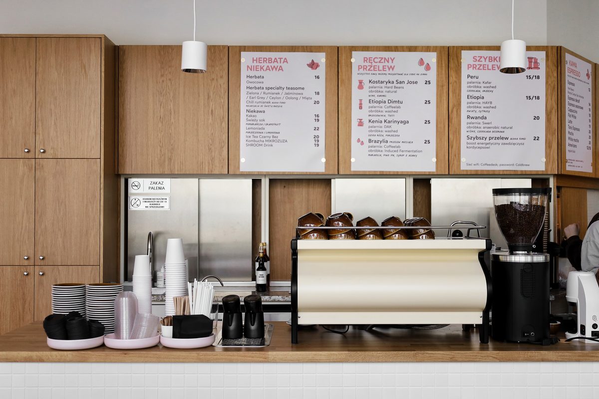 Bar kawiarni: ekspres, menu nad ladą i stanowisko pracy baristy